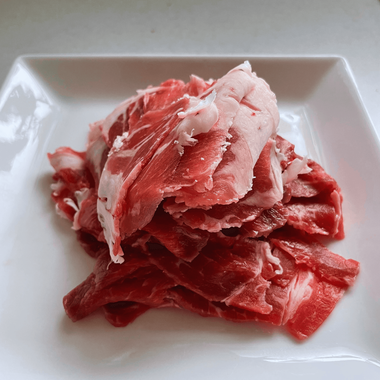 Thinly sliced beef arranged on a plate