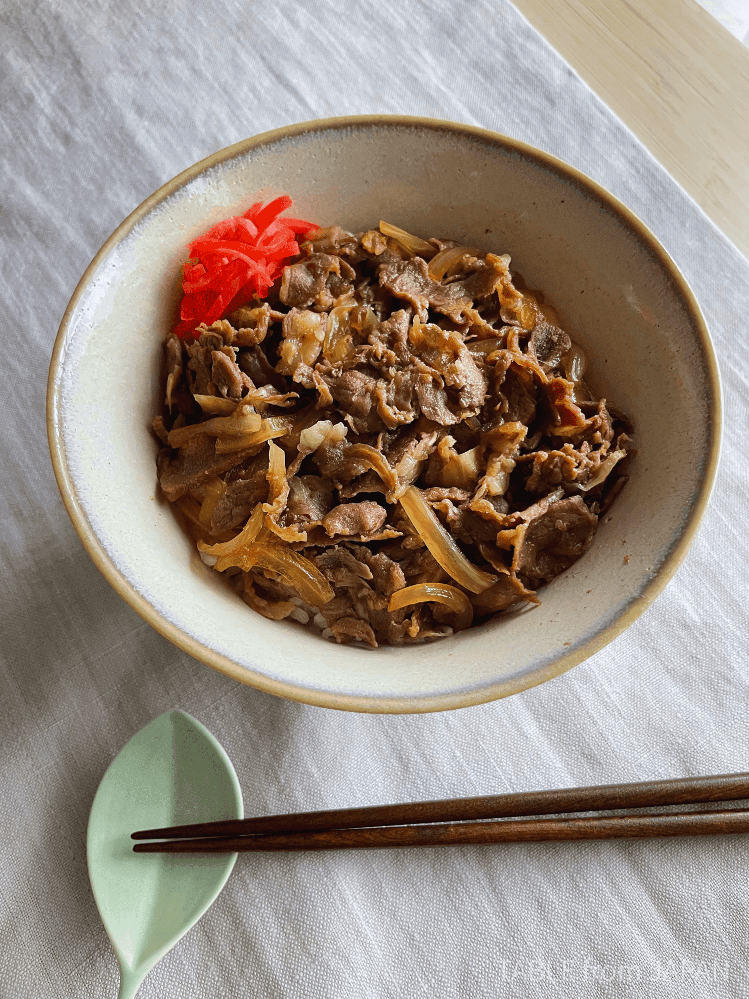 A bowl of gyudon with thinly sliced beef and onion over rice