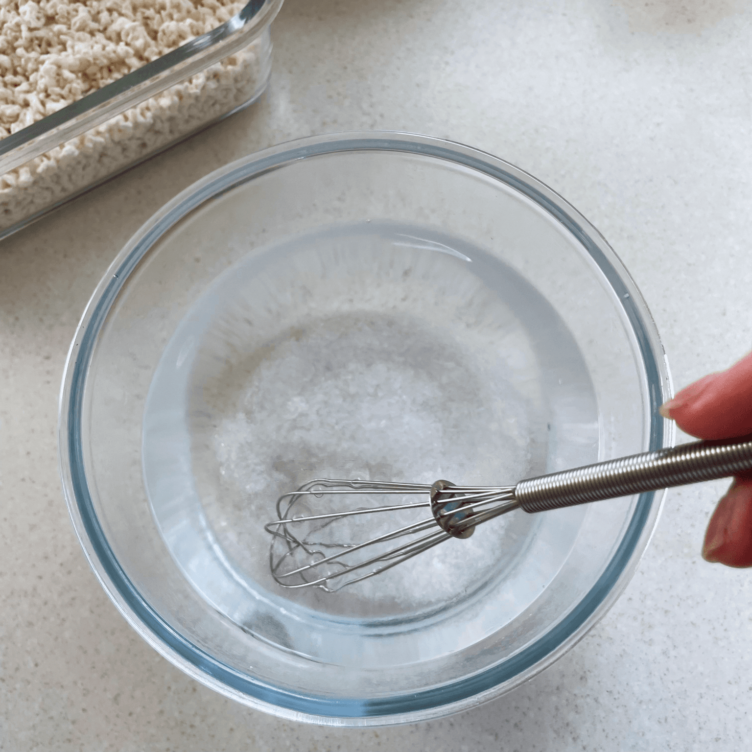 Sea salt being whisked into warm water for shio koji