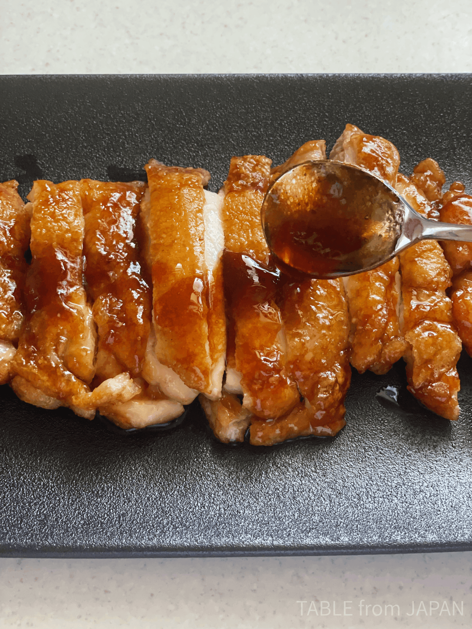 Teriyaki sauce being spooned over chicken