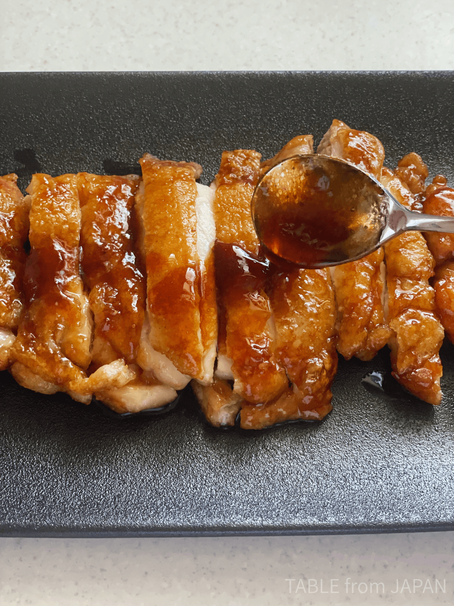 Teriyaki sauce being spooned over chicken
